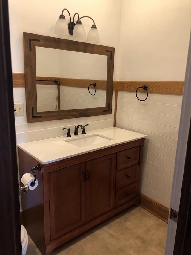 bathroom featuring vanity and tile walls