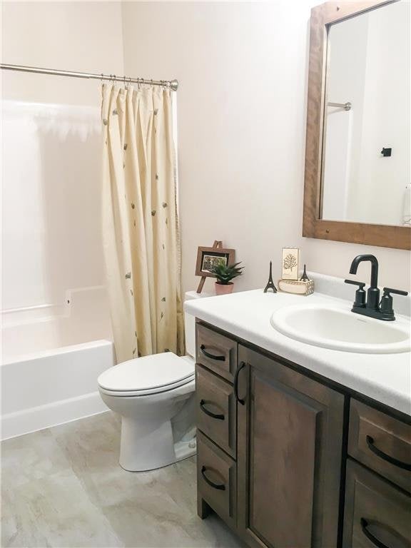 full bathroom featuring vanity, toilet, and shower / bathtub combination with curtain