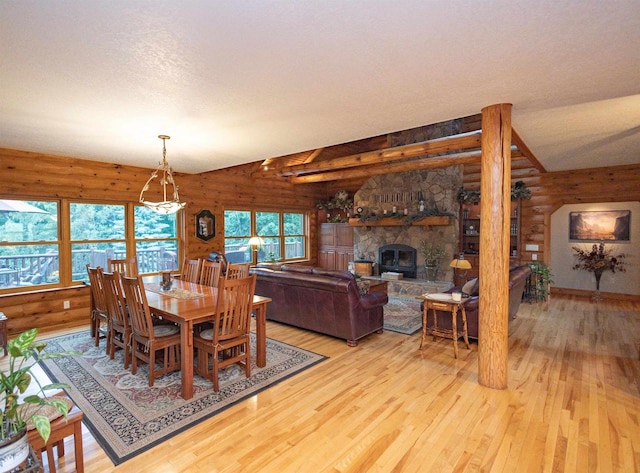 dining space with a fireplace, a textured ceiling, light hardwood / wood-style flooring, and lofted ceiling