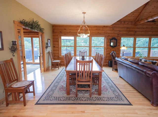 dining room with a chandelier, light hardwood / wood-style floors, and lofted ceiling