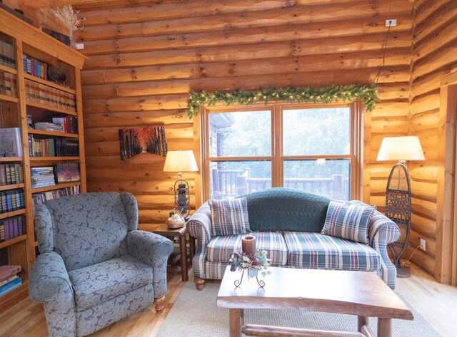 living room with rustic walls and light hardwood / wood-style flooring