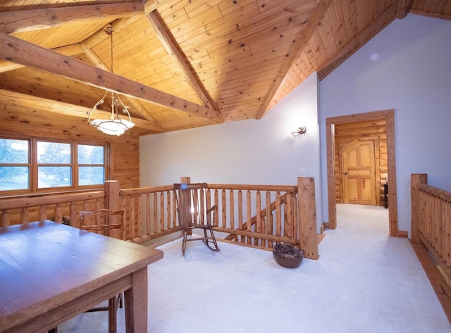 interior space featuring lofted ceiling with beams, light carpet, wooden walls, and wood ceiling