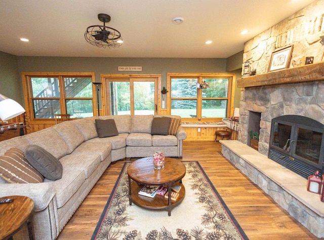 living room featuring hardwood / wood-style flooring and a stone fireplace