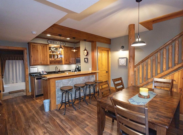 dining area with sink and dark wood-type flooring