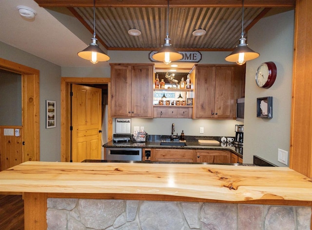 kitchen with pendant lighting, butcher block counters, and sink