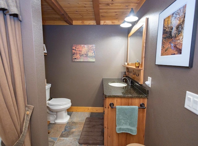 bathroom with beamed ceiling, vanity, toilet, and wooden ceiling