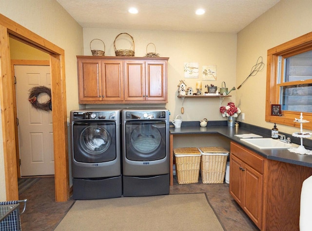 laundry room with cabinets, separate washer and dryer, and sink