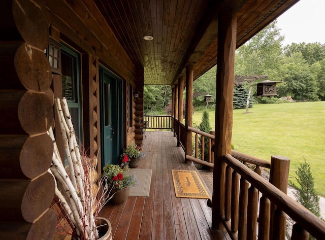 wooden terrace with a porch and a lawn