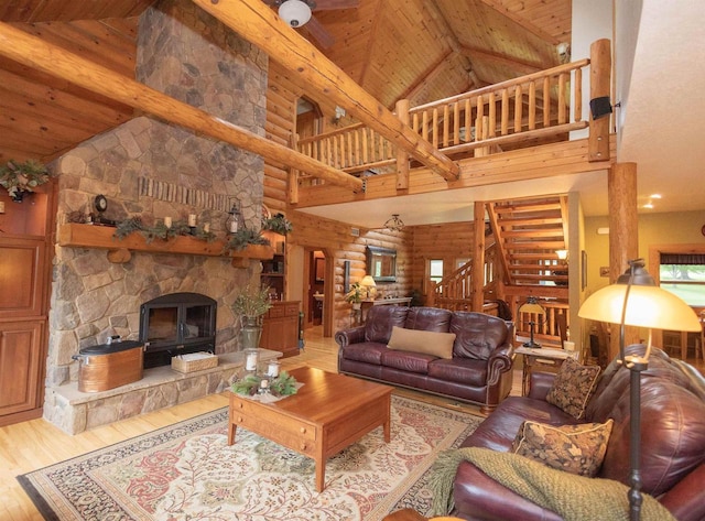 living room with beam ceiling, wooden ceiling, light hardwood / wood-style flooring, high vaulted ceiling, and a fireplace