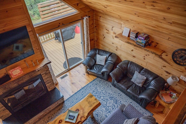 living room featuring wood walls, wood-type flooring, and vaulted ceiling