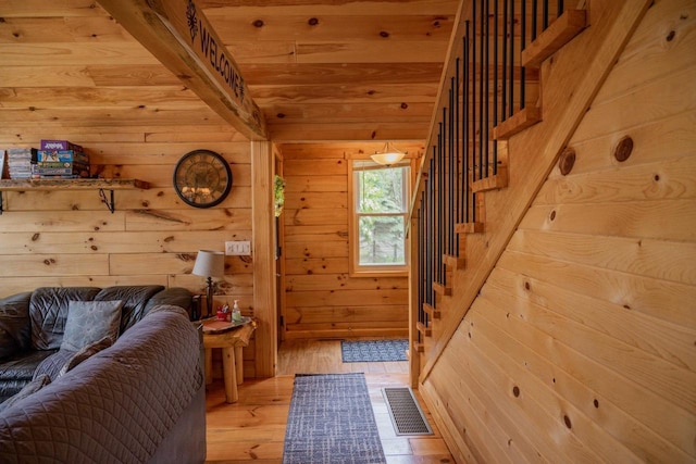 entrance foyer with light hardwood / wood-style floors and wood walls