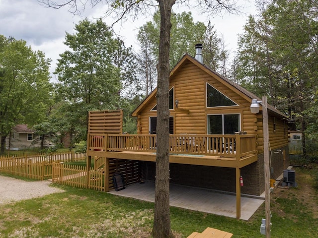 rear view of property with a lawn, a wooden deck, a patio area, and central AC unit