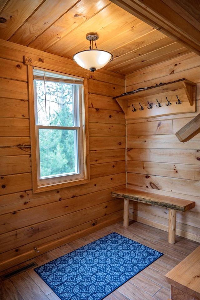 mudroom featuring wooden ceiling, hardwood / wood-style flooring, and wooden walls