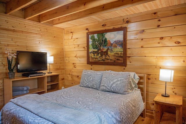 bedroom featuring hardwood / wood-style flooring, beam ceiling, and wood walls