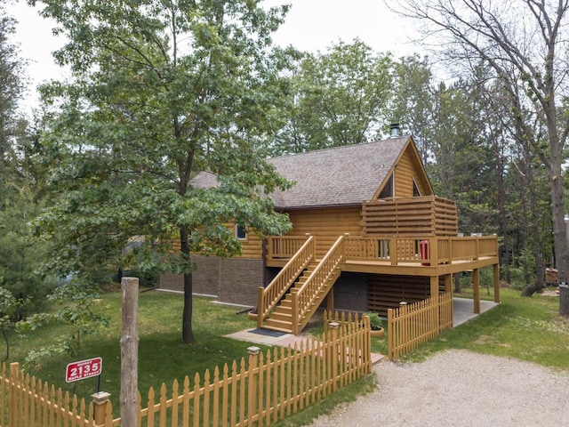 view of front of home featuring a front lawn and a wooden deck