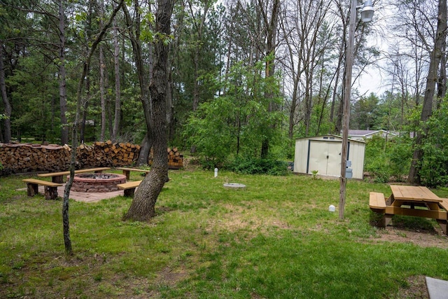 view of yard featuring a shed and a fire pit