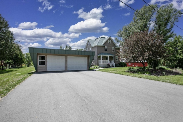 view of front of house featuring a front lawn, an outdoor structure, and a garage