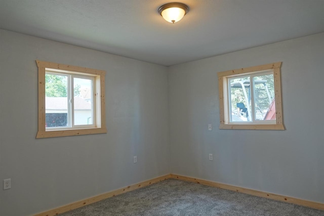 unfurnished room with a wealth of natural light and carpet