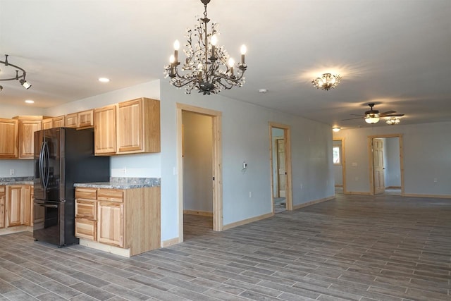 kitchen with black fridge, pendant lighting, wood-type flooring, and ceiling fan with notable chandelier