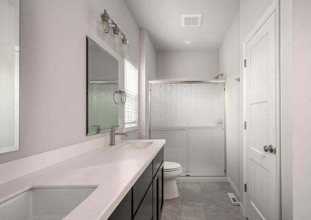 bathroom featuring tile patterned floors, vanity, toilet, and walk in shower