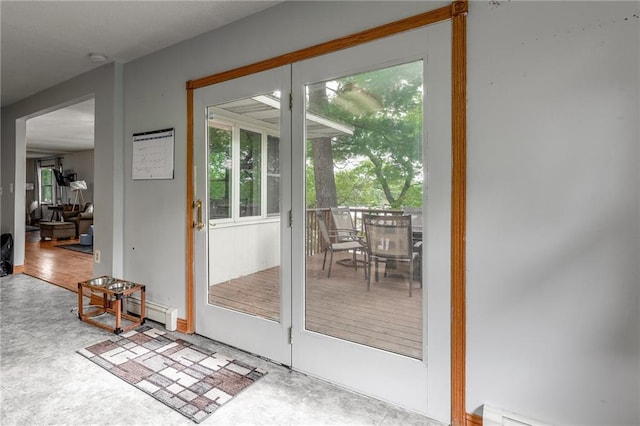 doorway to outside with concrete flooring and baseboard heating