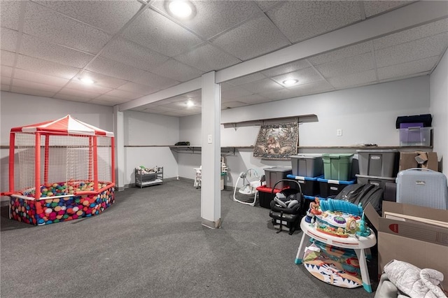 recreation room featuring carpet and a drop ceiling