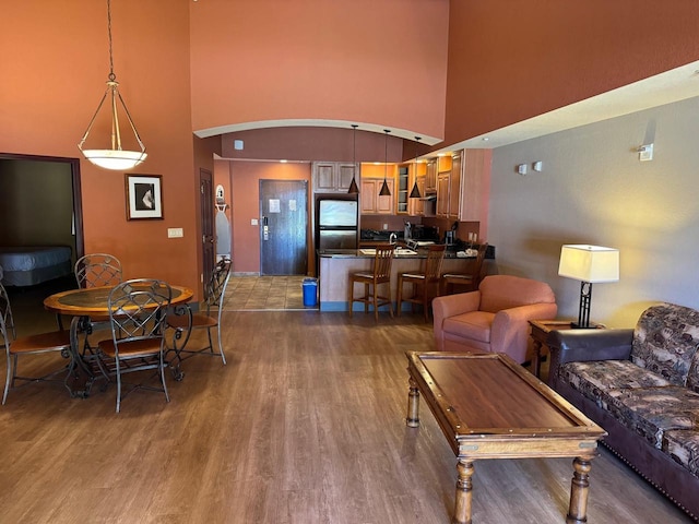 living room featuring hardwood / wood-style flooring and a towering ceiling