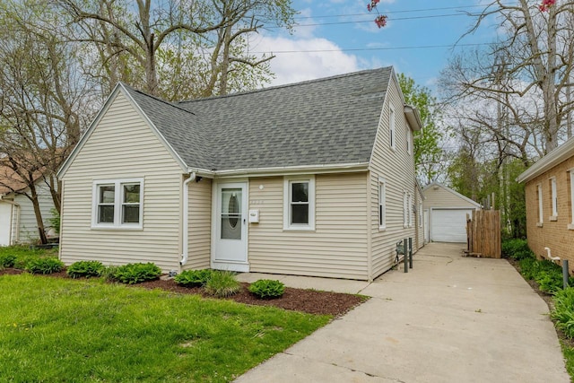 view of front of house with an outbuilding, a front lawn, and a garage