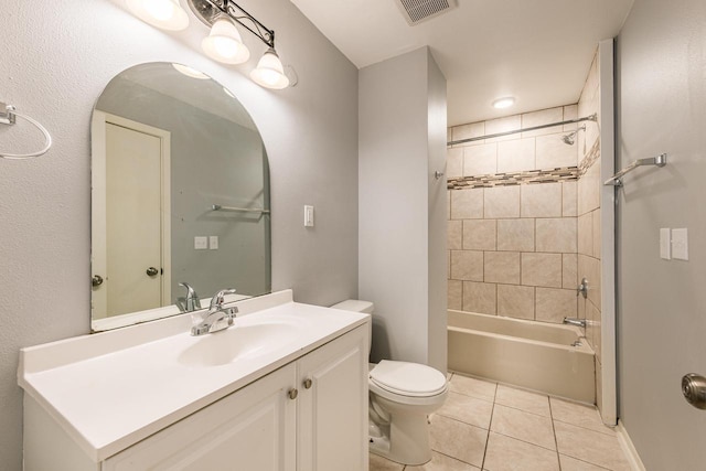 full bathroom with tile patterned flooring, vanity, tiled shower / bath combo, and toilet