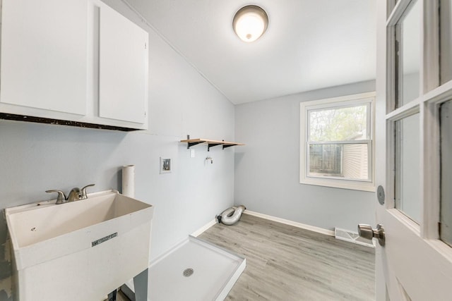 washroom with cabinets, hookup for a washing machine, light wood-type flooring, and sink