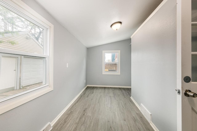 interior space with light wood-type flooring and lofted ceiling