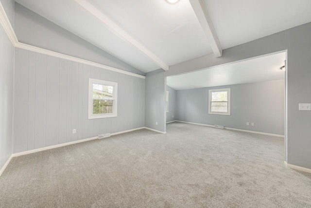 carpeted spare room with vaulted ceiling with beams and plenty of natural light