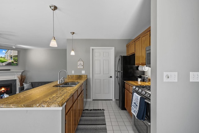 kitchen with sink, light tile patterned floors, decorative light fixtures, kitchen peninsula, and stainless steel appliances