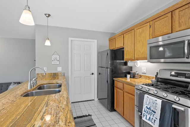 kitchen with sink, light tile patterned flooring, stainless steel appliances, and decorative light fixtures