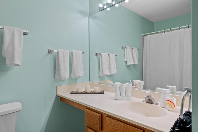 bathroom featuring a shower with curtain, vanity, and toilet