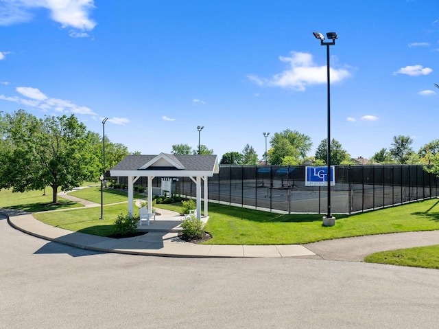 view of property's community with a gazebo, a lawn, and tennis court