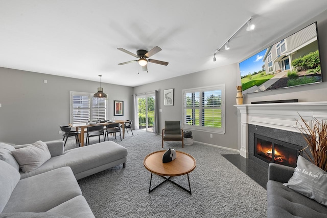 carpeted living room with track lighting and ceiling fan