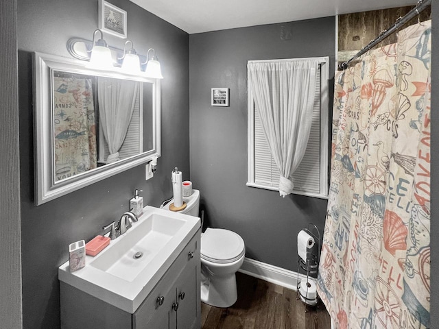 bathroom with hardwood / wood-style flooring, vanity, toilet, and walk in shower