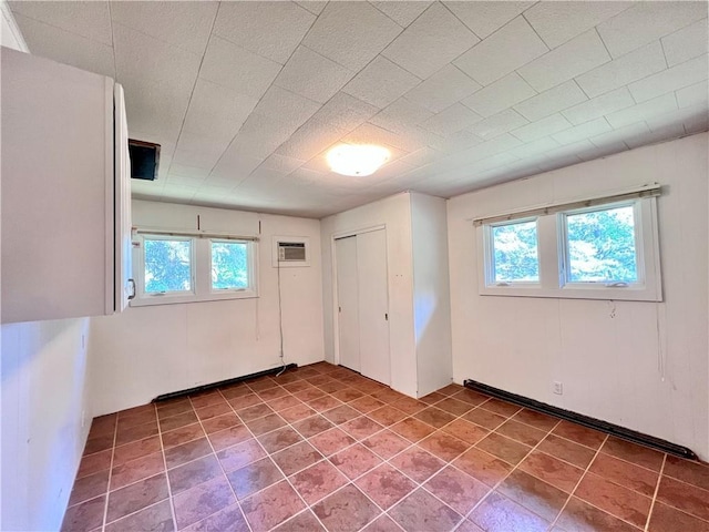 unfurnished room with an AC wall unit