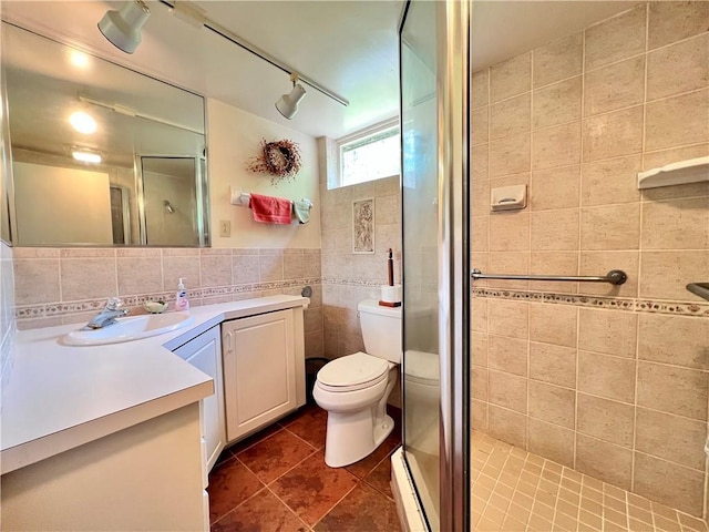 bathroom featuring tile patterned floors, walk in shower, vanity, tile walls, and toilet