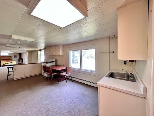 kitchen with white range with gas cooktop, sink, and a baseboard radiator