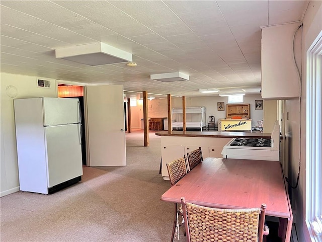 dining space featuring light colored carpet and plenty of natural light