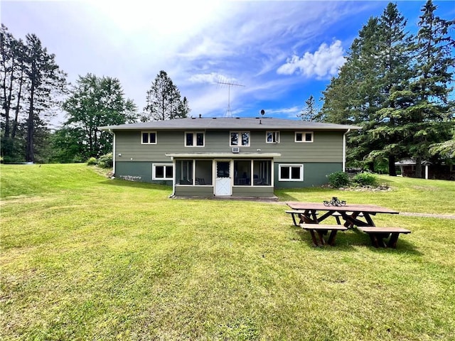 back of house with a yard and a sunroom