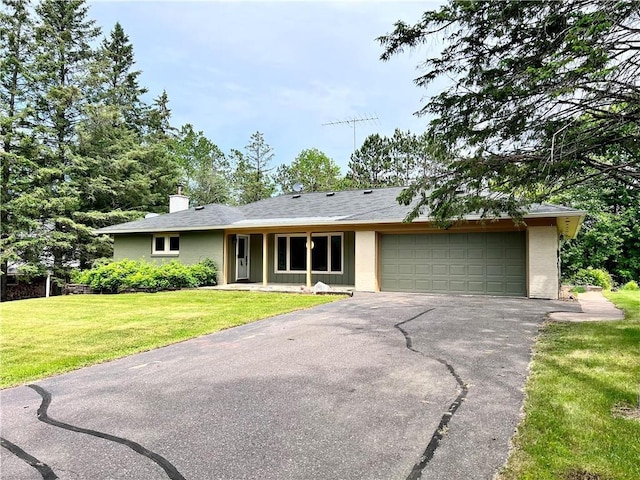 ranch-style home featuring a garage and a front lawn