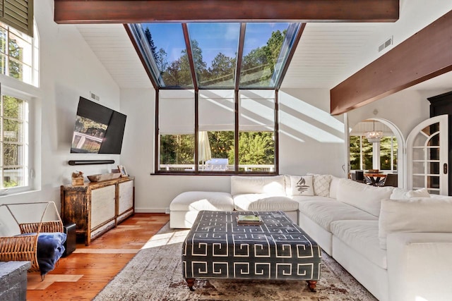 living room featuring hardwood / wood-style flooring and vaulted ceiling with skylight