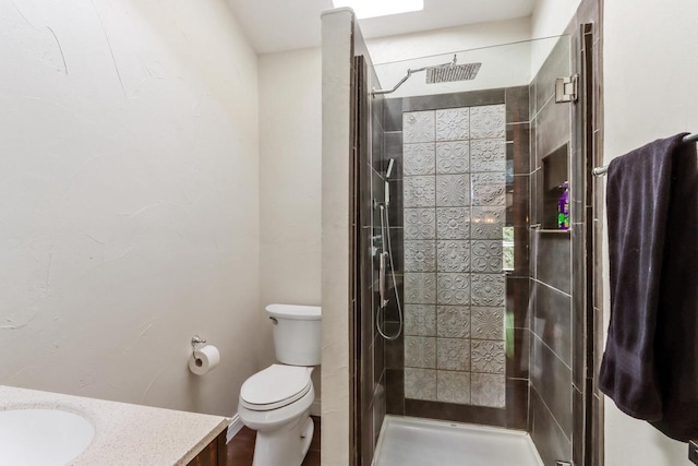 bathroom featuring toilet, vanity, and tiled shower