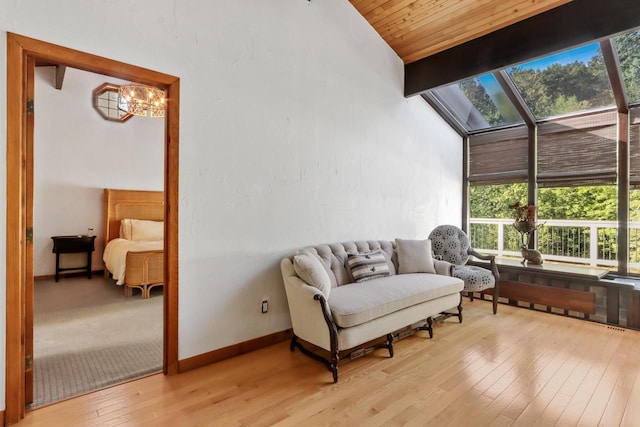 sunroom / solarium with a notable chandelier, vaulted ceiling with beams, and wooden ceiling