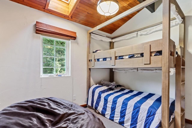 bedroom with lofted ceiling with skylight and wooden ceiling