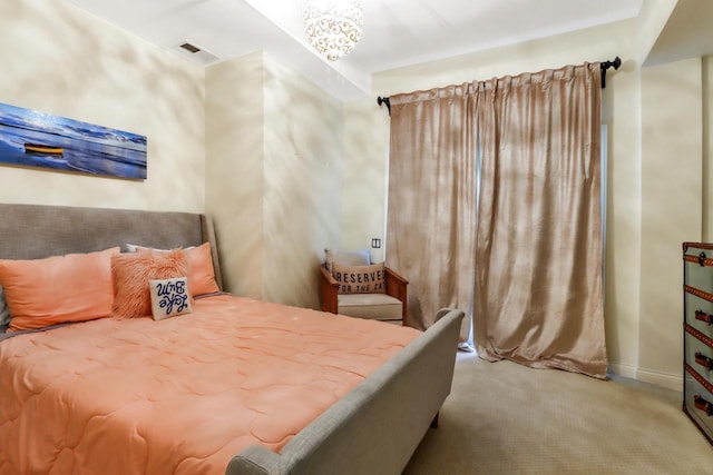 bedroom featuring light colored carpet and a notable chandelier