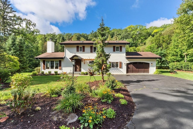 colonial home featuring solar panels, a garage, and a front lawn